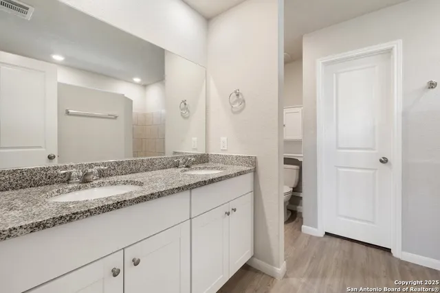 a bathroom with a granite countertop sink and a mirror
