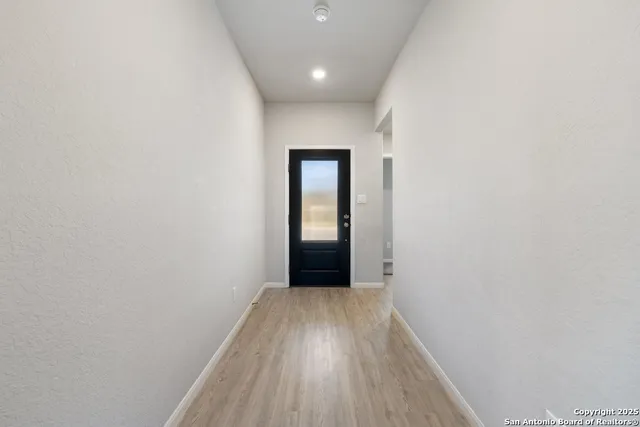 a view of hallway with wooden floor and a carpet