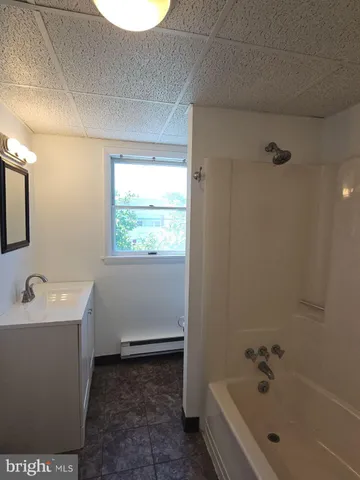 a bathroom with a bathtub sink and mirror