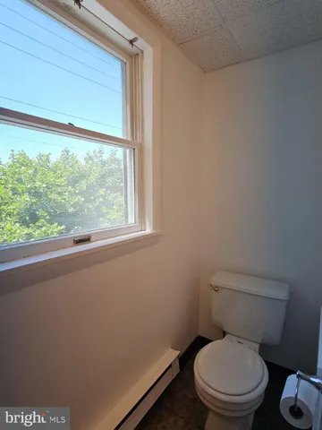 a white toilet sitting next to a window