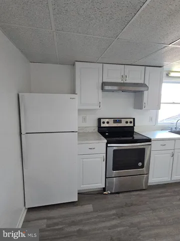 a kitchen with a refrigerator and a stove top oven