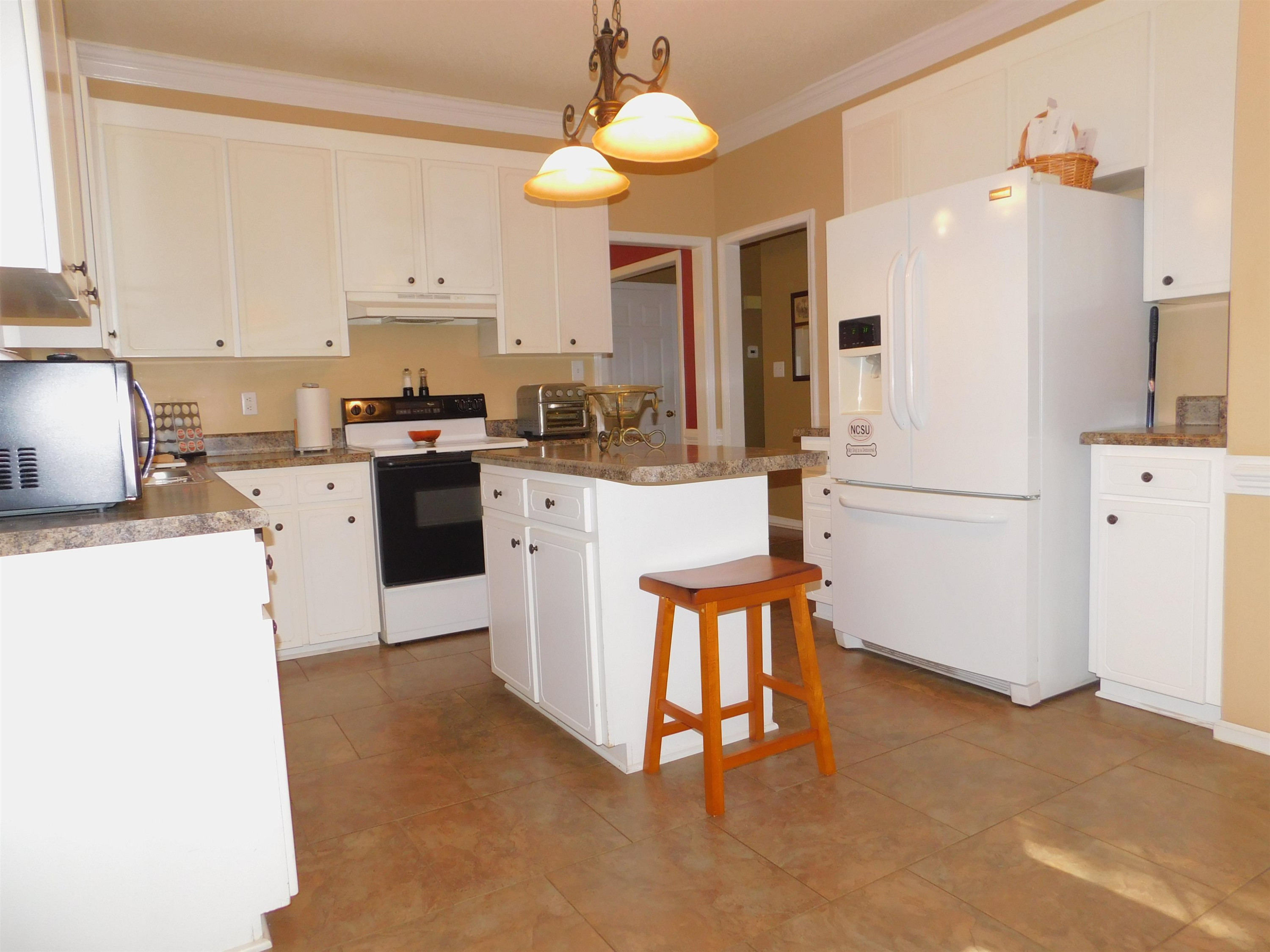 213 Goldfield Drive Garner, NC 27529 - Photo 10 of 18 a kitchen with stainless steel appliances granite countertop a refrigerator a stove top oven a sink dishwasher and white cabinets