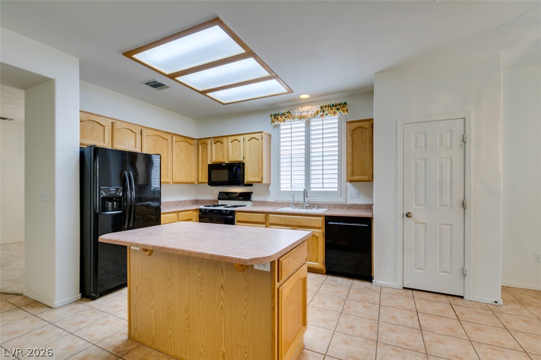 2189 Chapman Ranch Drive Henderson, NV 89012 - Photo 29 of 60 Oak cabinetry paired with tile flooring creates a classic foundation in this well-appointed kitchen.