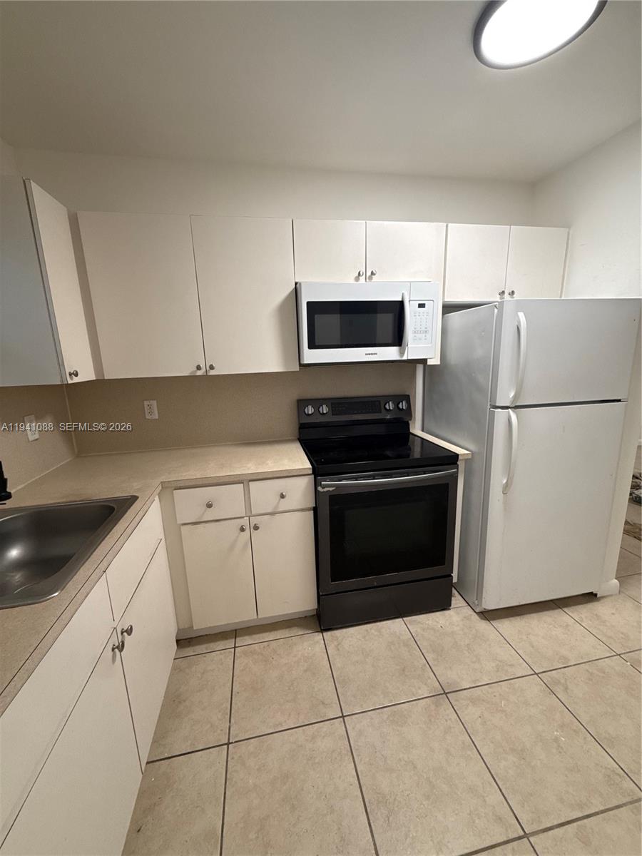 575 Northeast 82nd Street, Unit 10 Miami, FL 33138 - Photo 5 of 14 a kitchen with a stove top oven and refrigerator