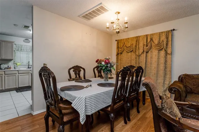 a view of a dining room with furniture and chandelier