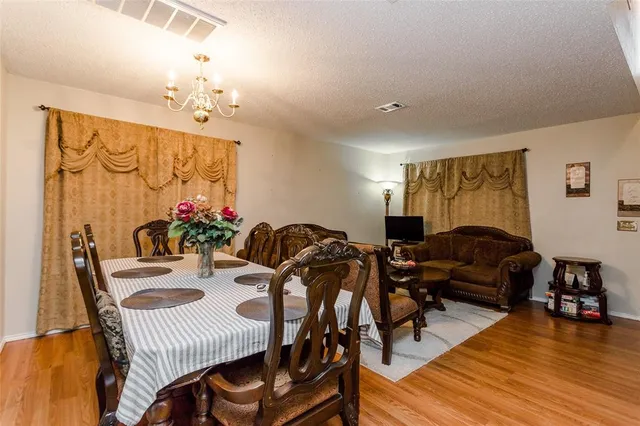 a living room with furniture flowers and wooden floor