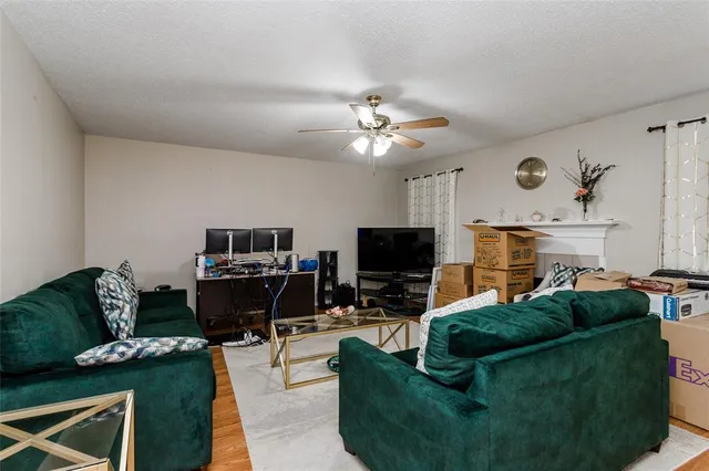 a living room with furniture a flat screen tv and kitchen view