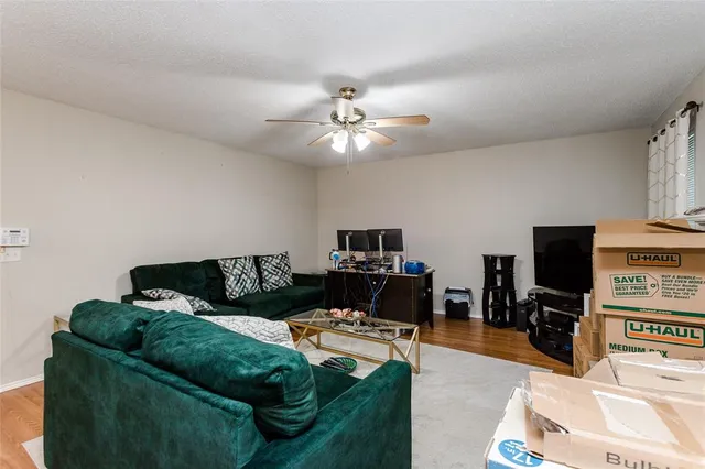 a living room with furniture a flat screen tv and a window