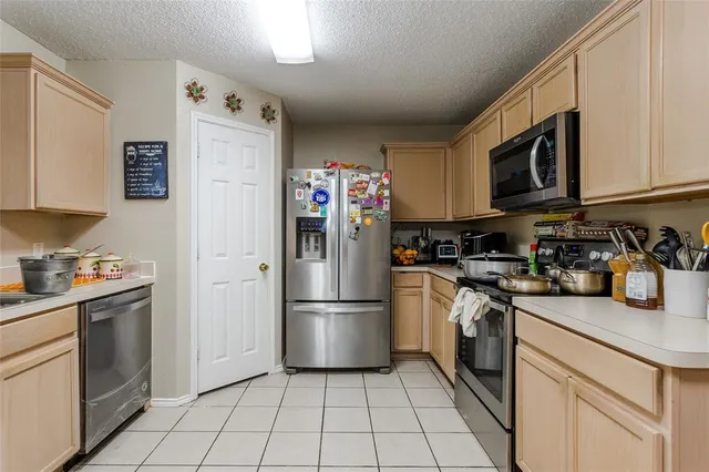 a kitchen with stainless steel appliances granite countertop a refrigerator sink and stove top oven