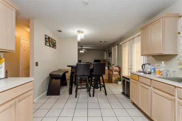 a kitchen with stainless steel appliances a table and chairs in it