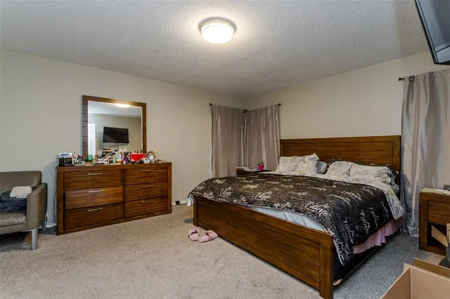 a bedroom with a bed and a mirror on dresser