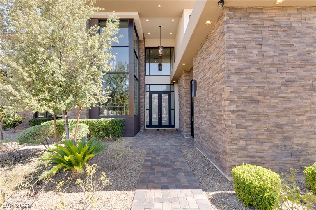 5 Crystal Tree Pass Henderson, NV 89052 - Photo 2 of 67 A grand entry with a stacked stone facade and dramatic tall glass panels welcomes all.