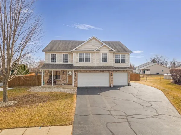 a front view of a house with a yard and trees