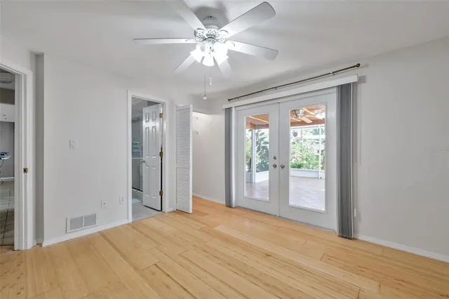 a view of a room with wooden floor and a ceiling fan