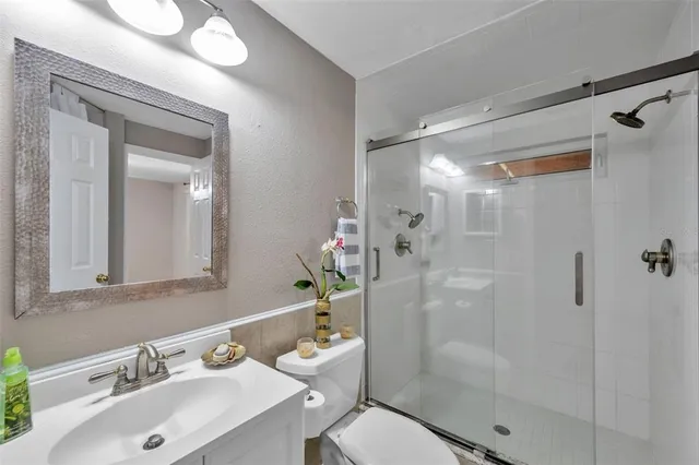 a bathroom with a sink mirror toilet and shower