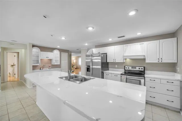 a large white kitchen with stainless steel appliances