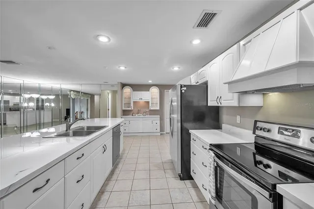 a large kitchen with a large counter top stainless steel appliances and cabinets