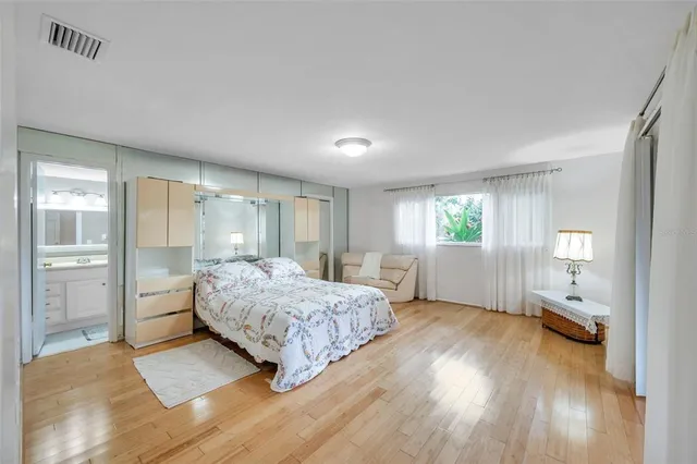 a bedroom with a bed and wooden floor