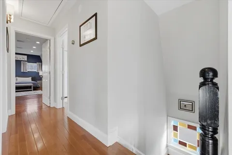 a view of a hallway with wooden floor and staircase