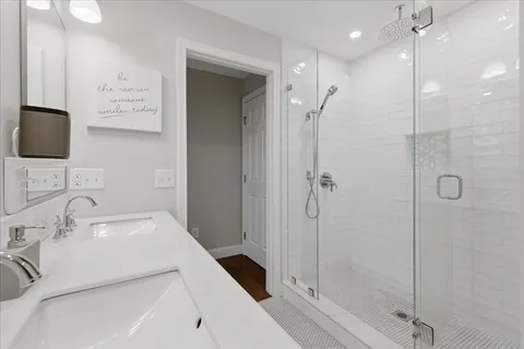 a view of a hallway with wooden floor and windows in a room