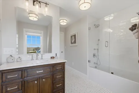 a bathroom with a tub sink double vanity and mirror