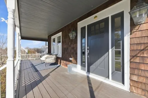 a view of a two chairs in the balcony next to a yard