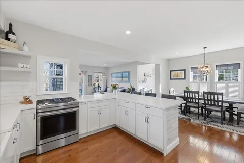 a kitchen with a stove a sink and a dining table view