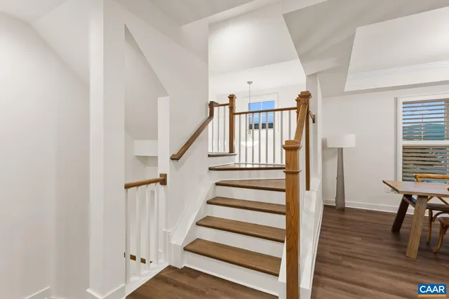 a kitchen with stainless steel appliances a dining table chairs refrigerator sink and microwave