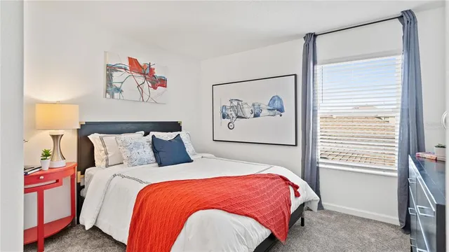 a bed sitting in a bedroom next to a window