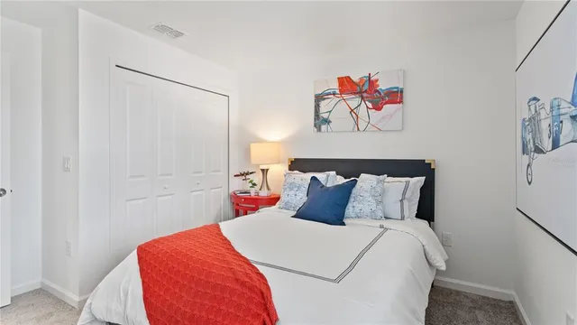 a bedroom with a bed and a painting on the wall