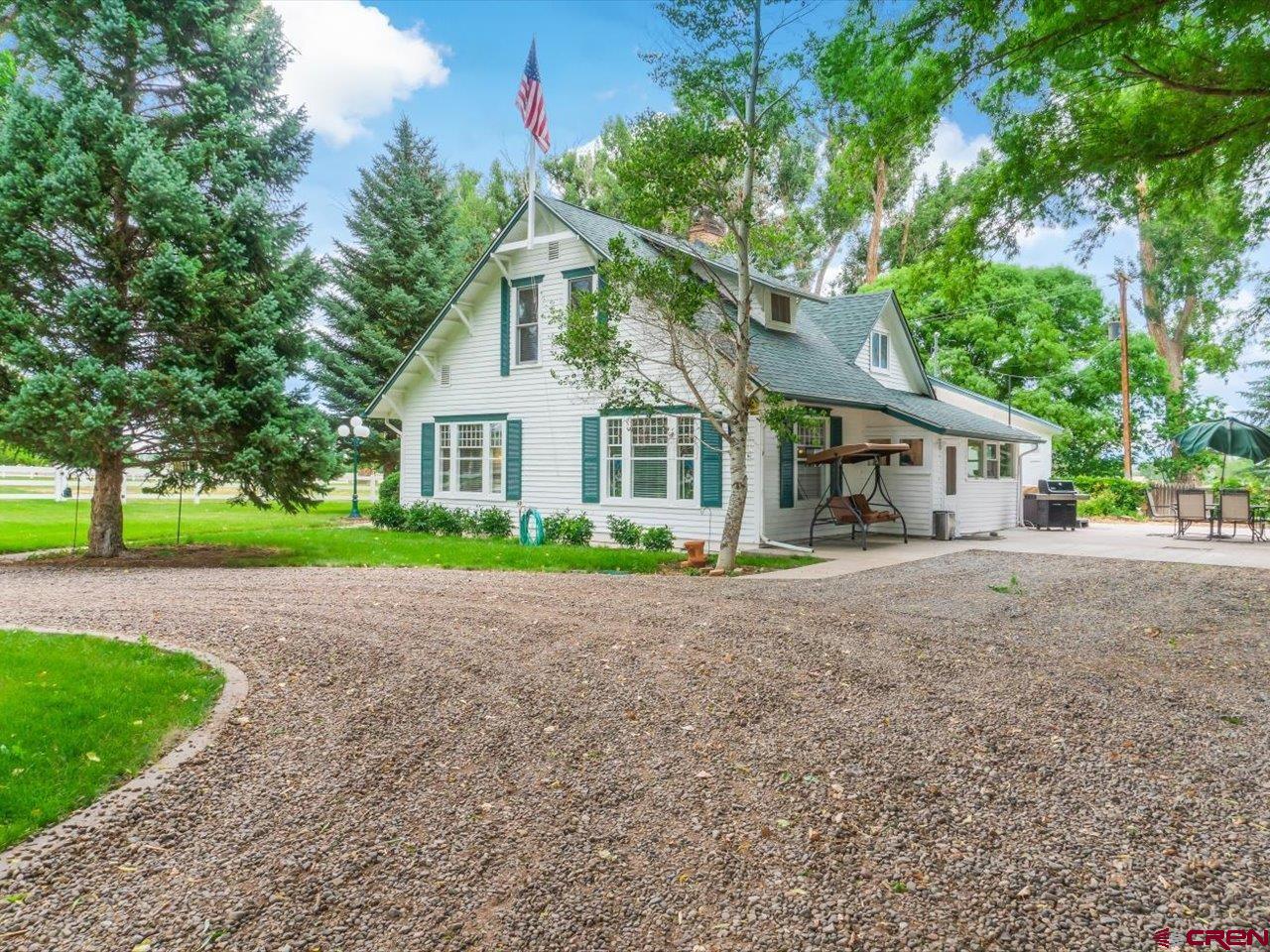 a view of a house with a garden and large trees