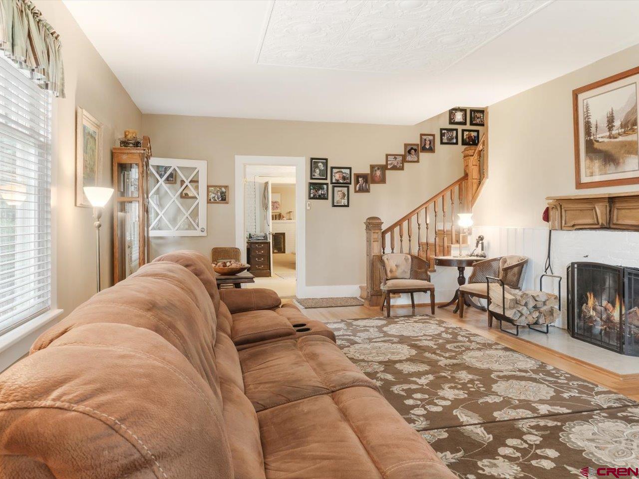 15318 6100th Road Montrose, CO 81403 - Photo 10 of 35 a living room with furniture a fireplace and a large window