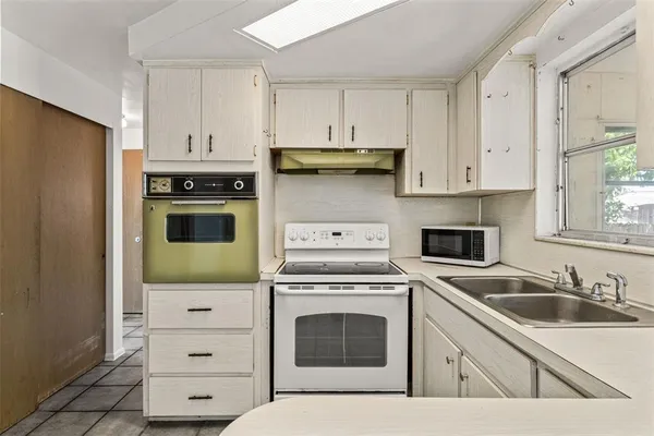 a kitchen with stainless steel appliances a sink a stove and cabinets