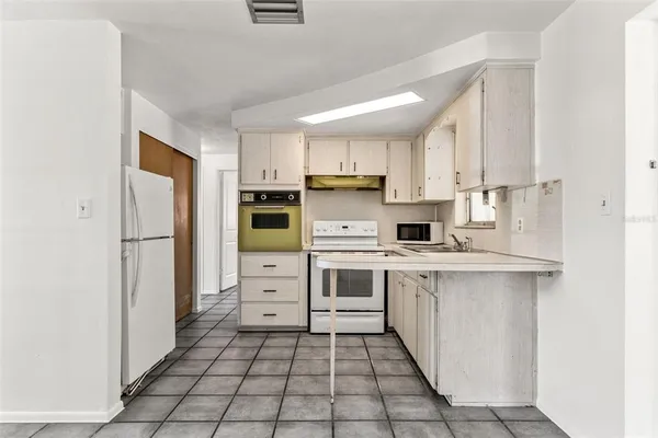 a kitchen with cabinets stainless steel appliances and a counter space