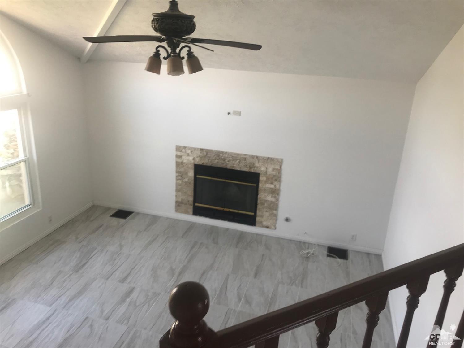 68535 Risueno Road Cathedral City, CA 92234 - Photo 4 of 15 a room with a fireplace and ceiling fan