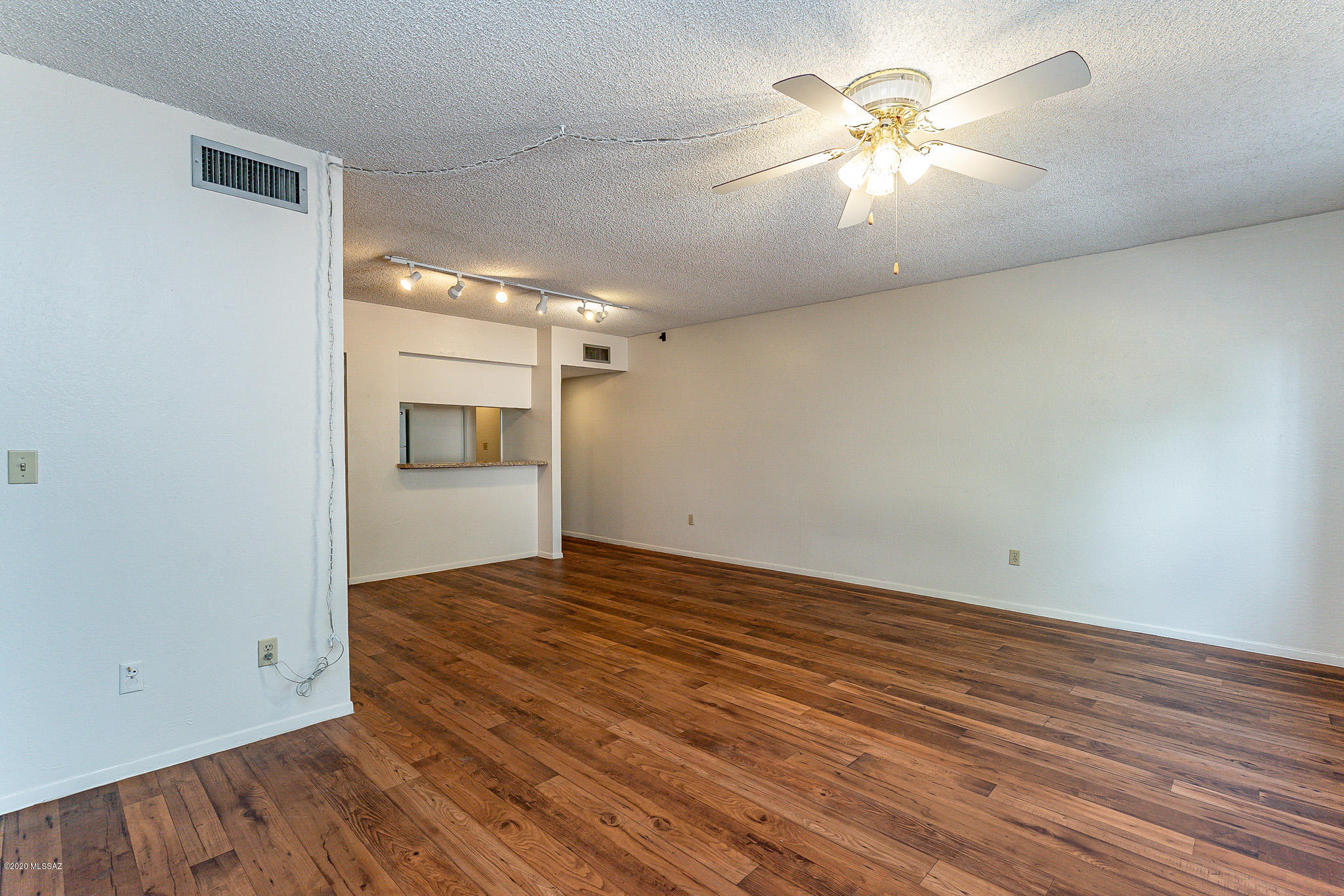3750 North Country Club Road, Unit 7 Tucson, AZ 85716 - Photo 5 of 26 a view of empty room with wooden floor and fan