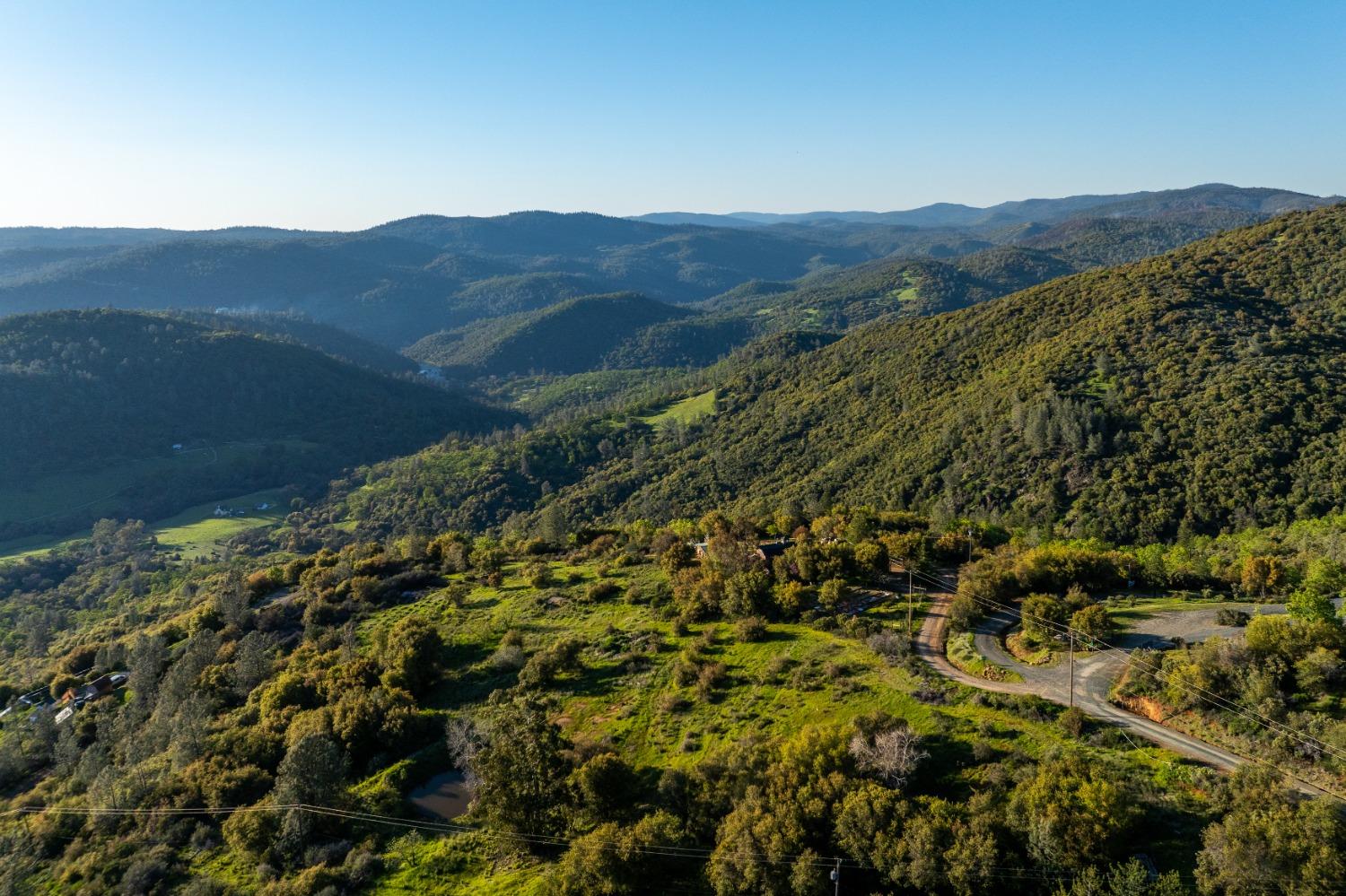 18678 Kentucky Ravine Road Nevada City, CA 95959 - Photo 8 of 11 a view of a lush green hillside and a building