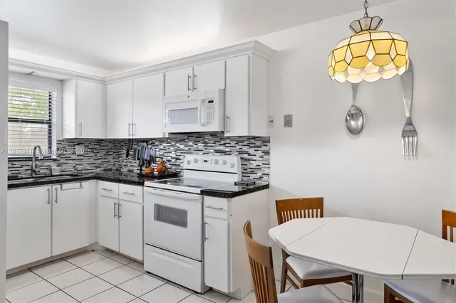 a kitchen with stainless steel appliances a stove a sink cabinets and a window