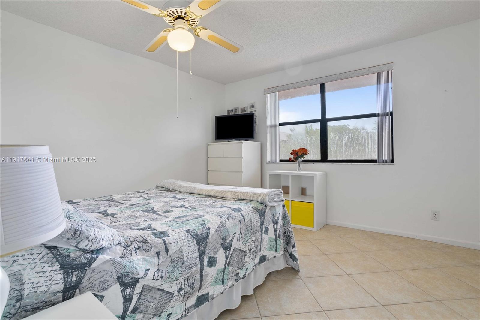 10207 Sunrise Lakes Boulevard, Unit 203 Sunrise, FL 33322 - Photo 18 of 39 a bedroom with a bed and a chandelier
