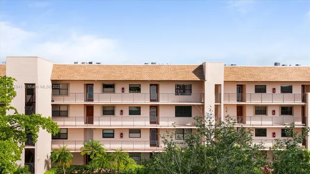 a view of a building with a lot of plants and trees