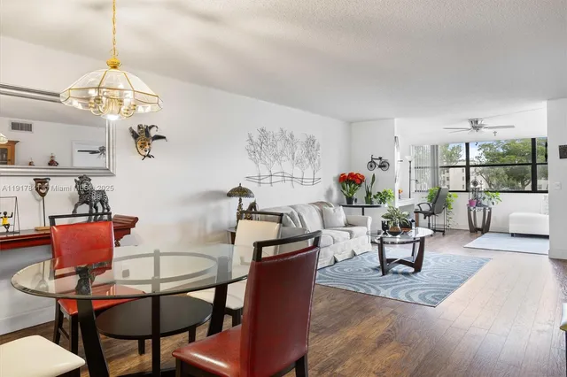 a view of a dining room with furniture a chandelier and wooden floor