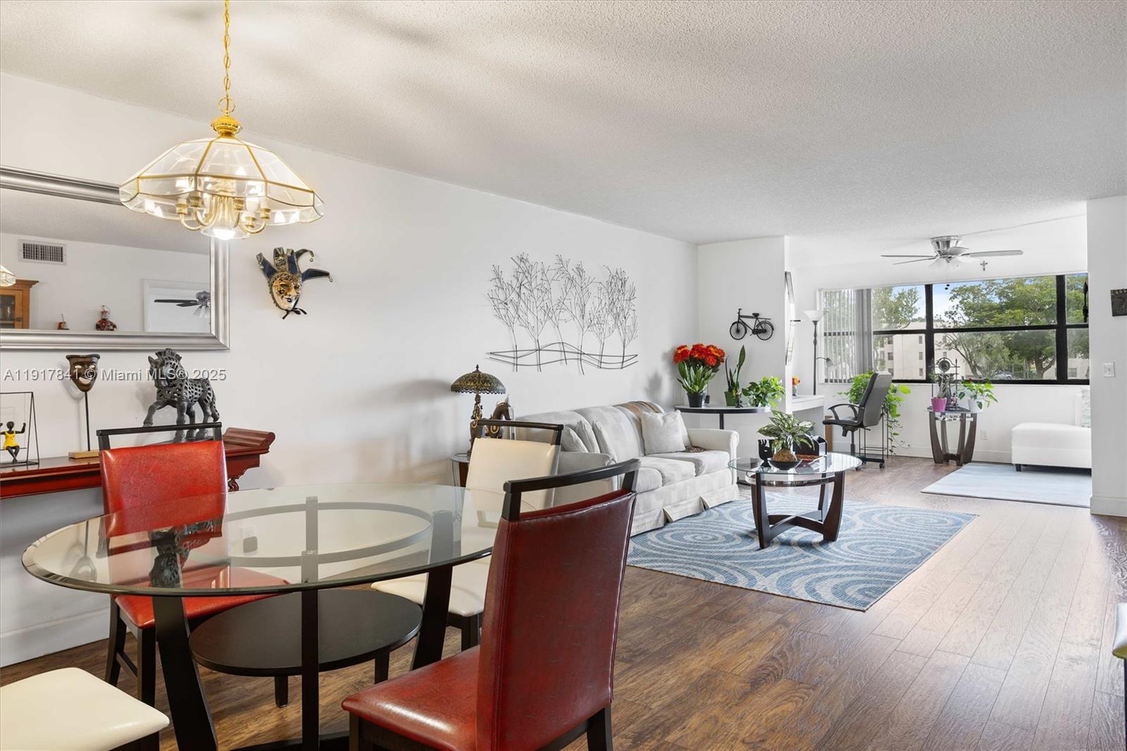10207 Sunrise Lakes Boulevard, Unit 203 Sunrise, FL 33322 - Photo 7 of 39 a view of a dining room with furniture a chandelier and wooden floor