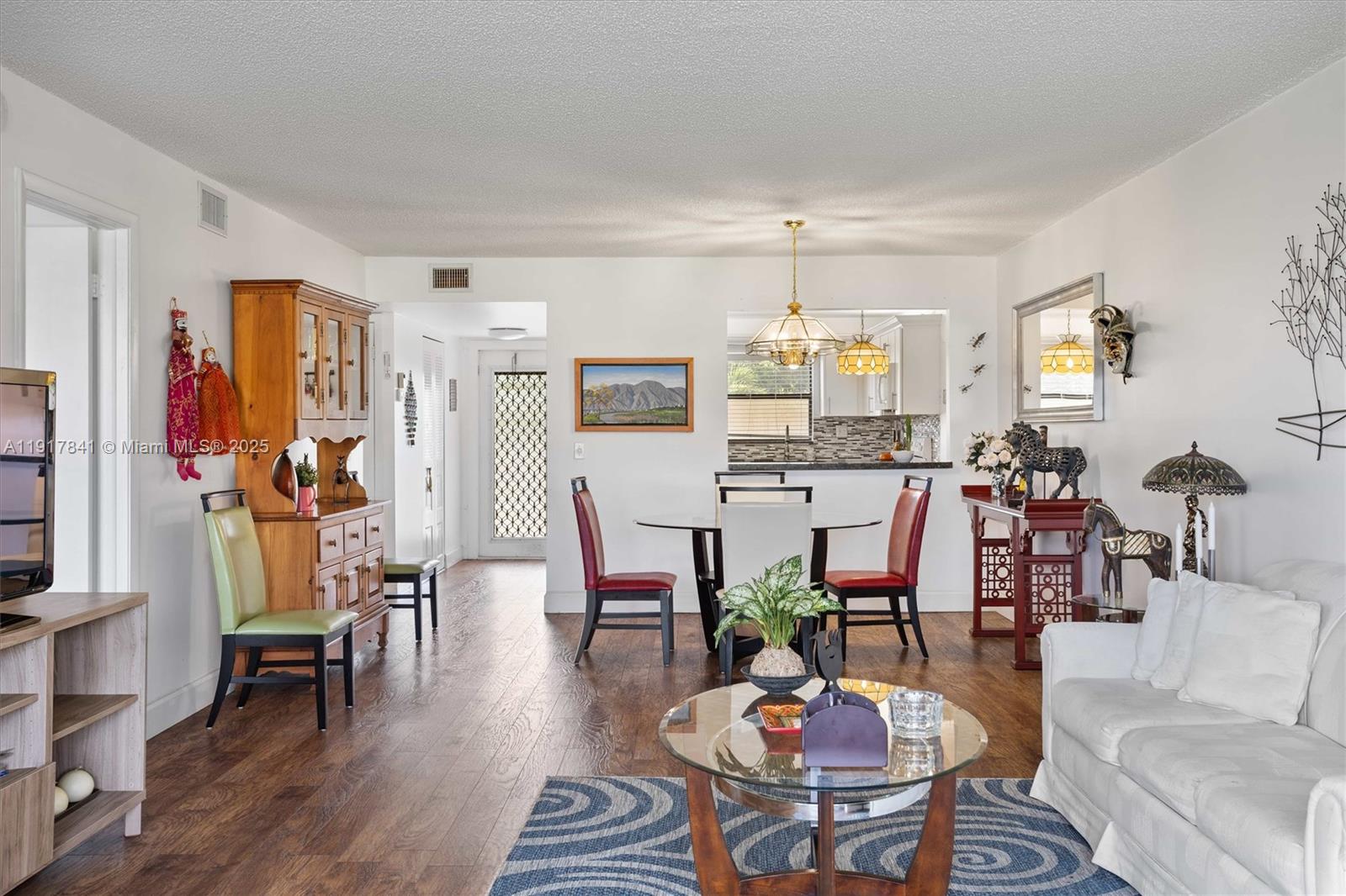 10207 Sunrise Lakes Boulevard, Unit 203 Sunrise, FL 33322 - Photo 9 of 39 a living room with lots of furniture and wooden floor