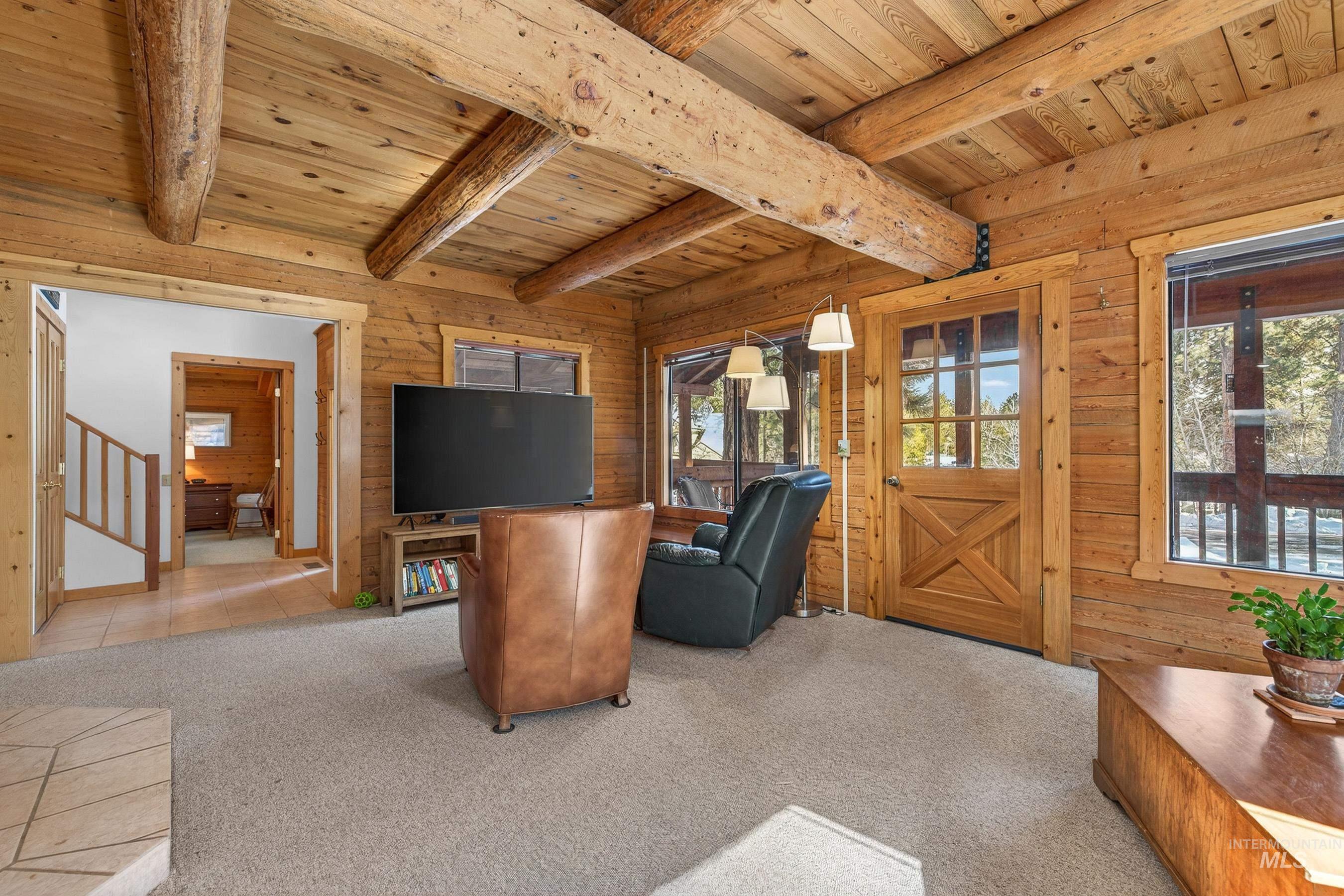 441 Allen Avenue McCall, ID 83638 - Photo 22 of 46 Living area featuring wood walls, carpet, and a wood ceiling with exposed beams
