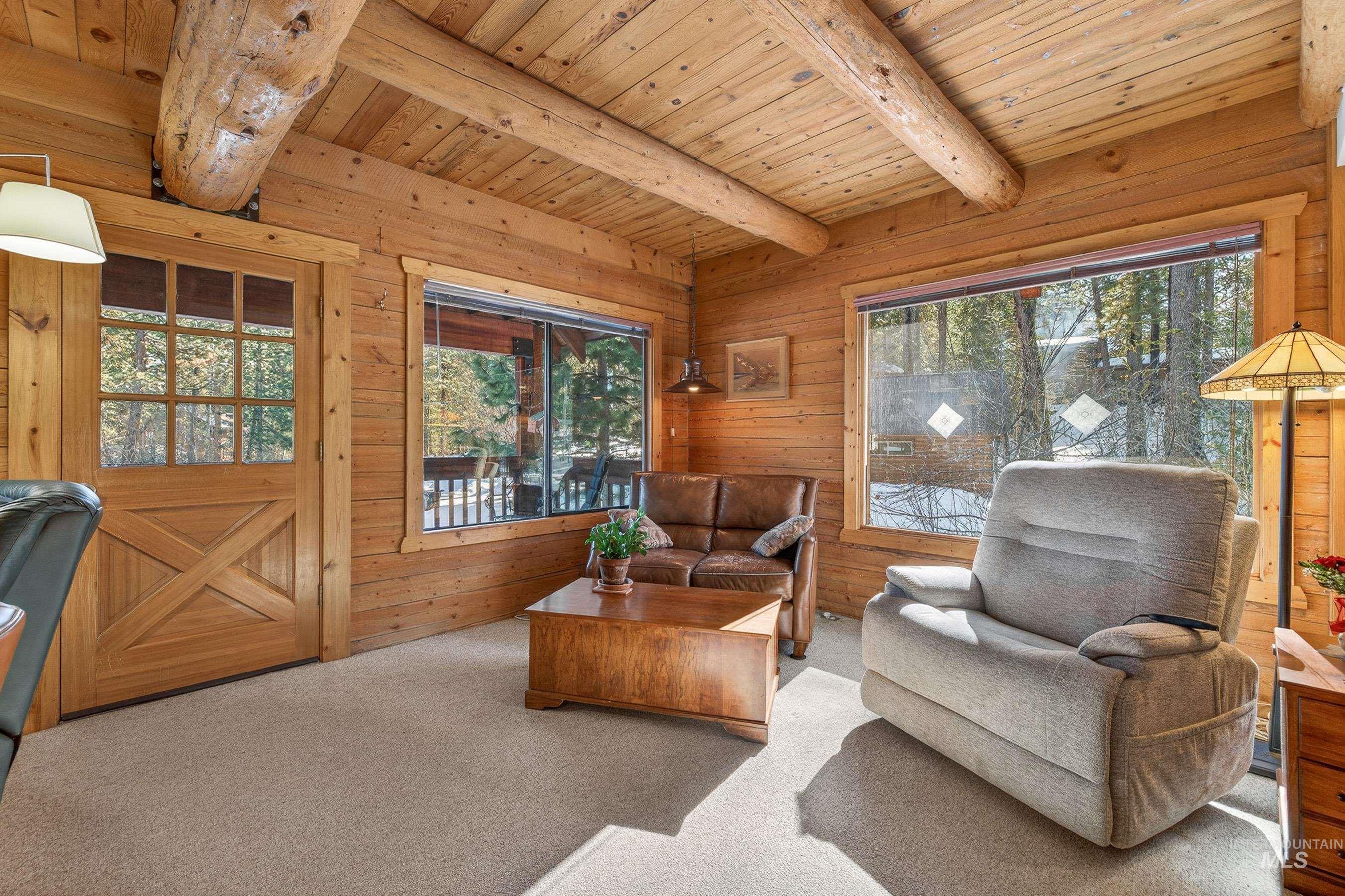 441 Allen Avenue McCall, ID 83638 - Photo 24 of 46 Carpeted living area featuring a wood ceiling with exposed beams and wooden walls