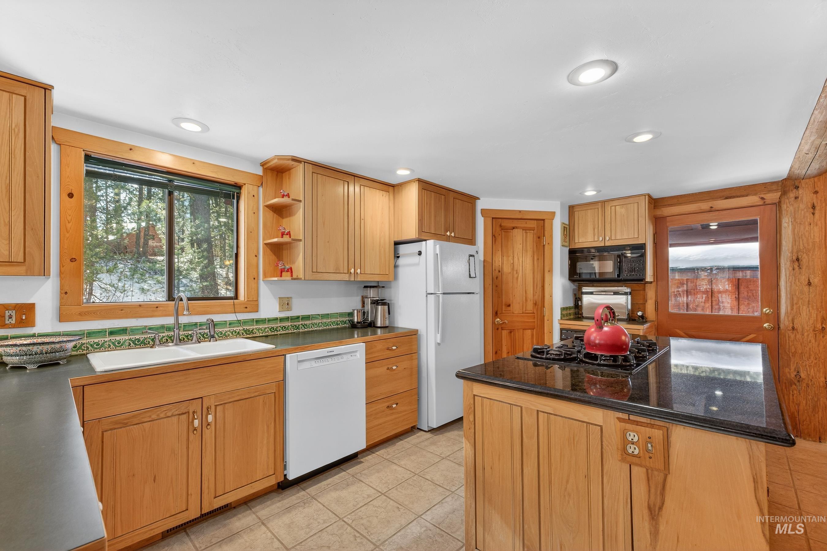 441 Allen Avenue McCall, ID 83638 - Photo 27 of 46 Kitchen with black appliances, open shelves, and light tile patterned floors