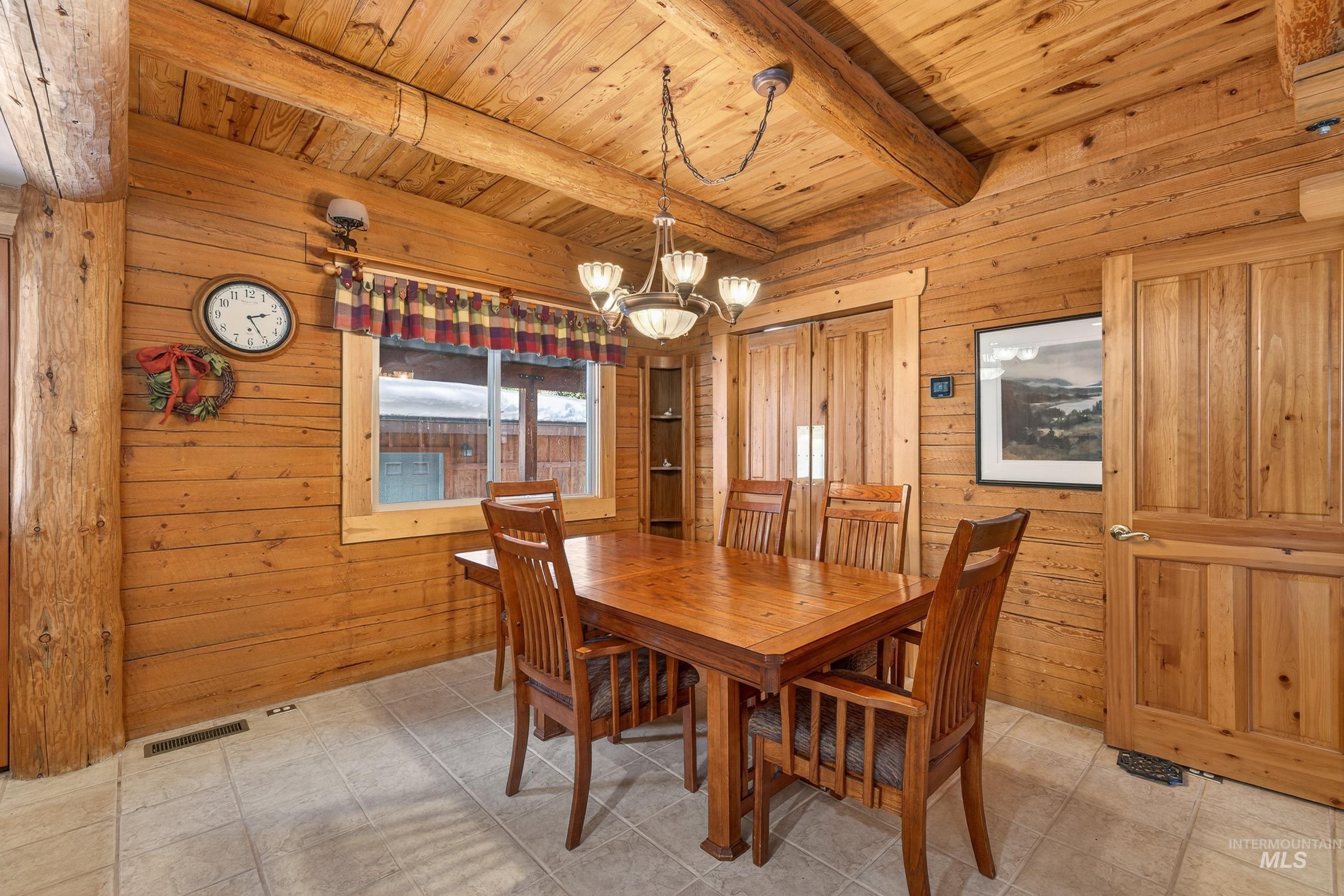 441 Allen Avenue McCall, ID 83638 - Photo 31 of 46 Dining area with wooden walls, suspended lighting, and a wooden ceiling with exposed beams