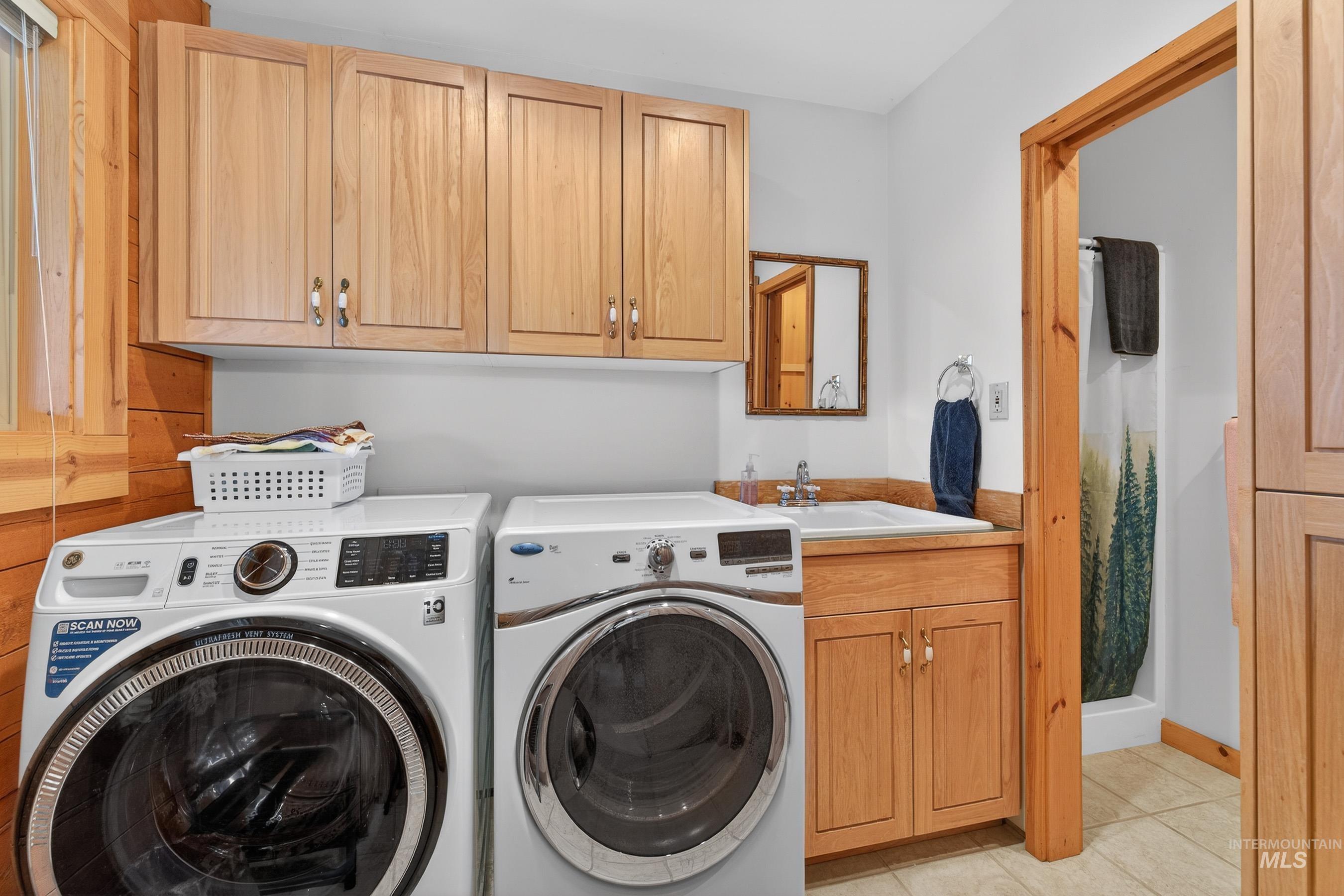 441 Allen Avenue McCall, ID 83638 - Photo 32 of 46 Laundry room with washing machine and clothes dryer, light tile patterned flooring, and cabinet space