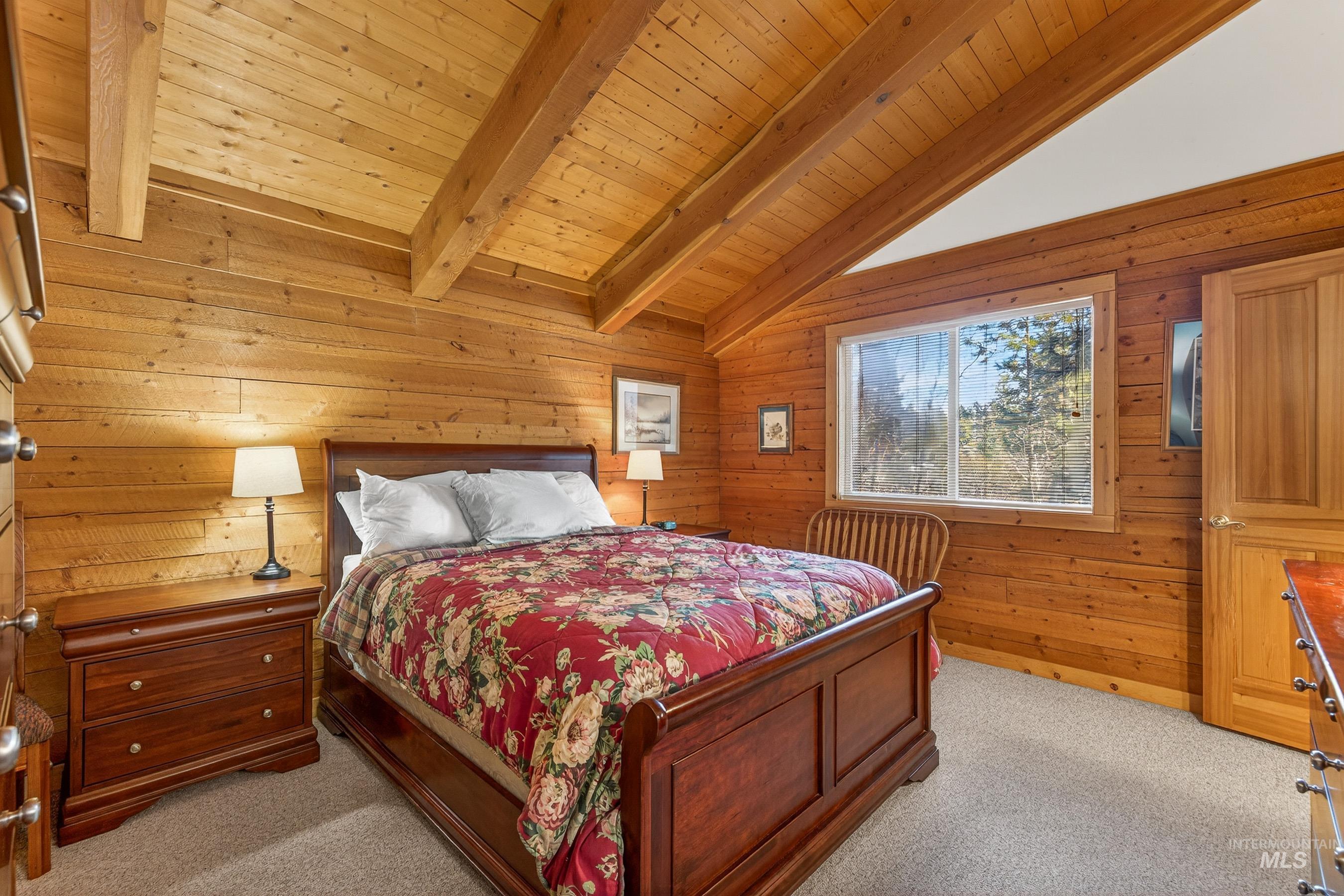 441 Allen Avenue McCall, ID 83638 - Photo 33 of 46 Bedroom with wooden walls, light carpet, wood ceiling, and vaulted ceiling with beams