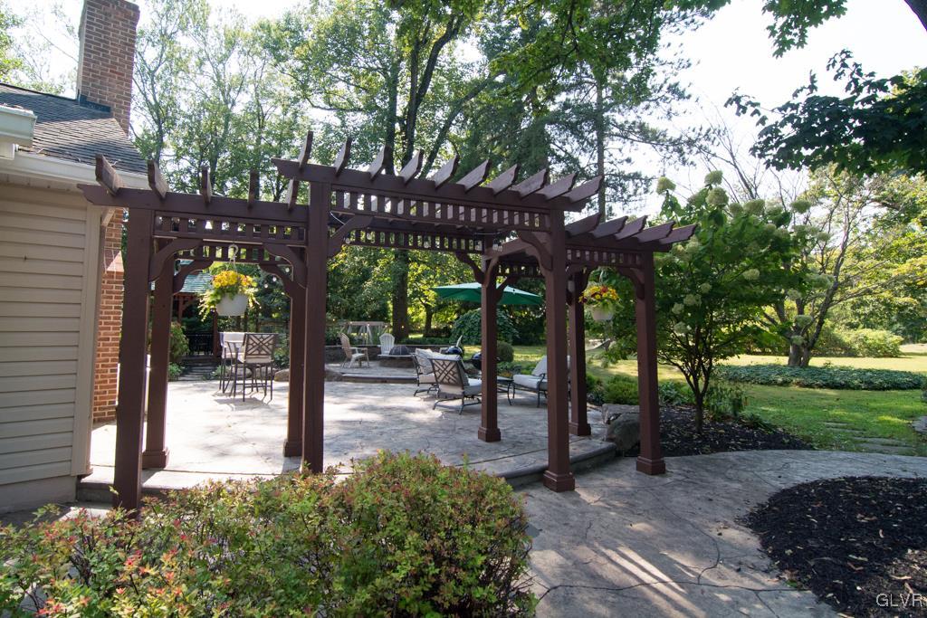 1470 Benner School Road Quakertown, PA 18951 - Photo 39 of 47 a view of a patio with table and chairs under an umbrella with large trees